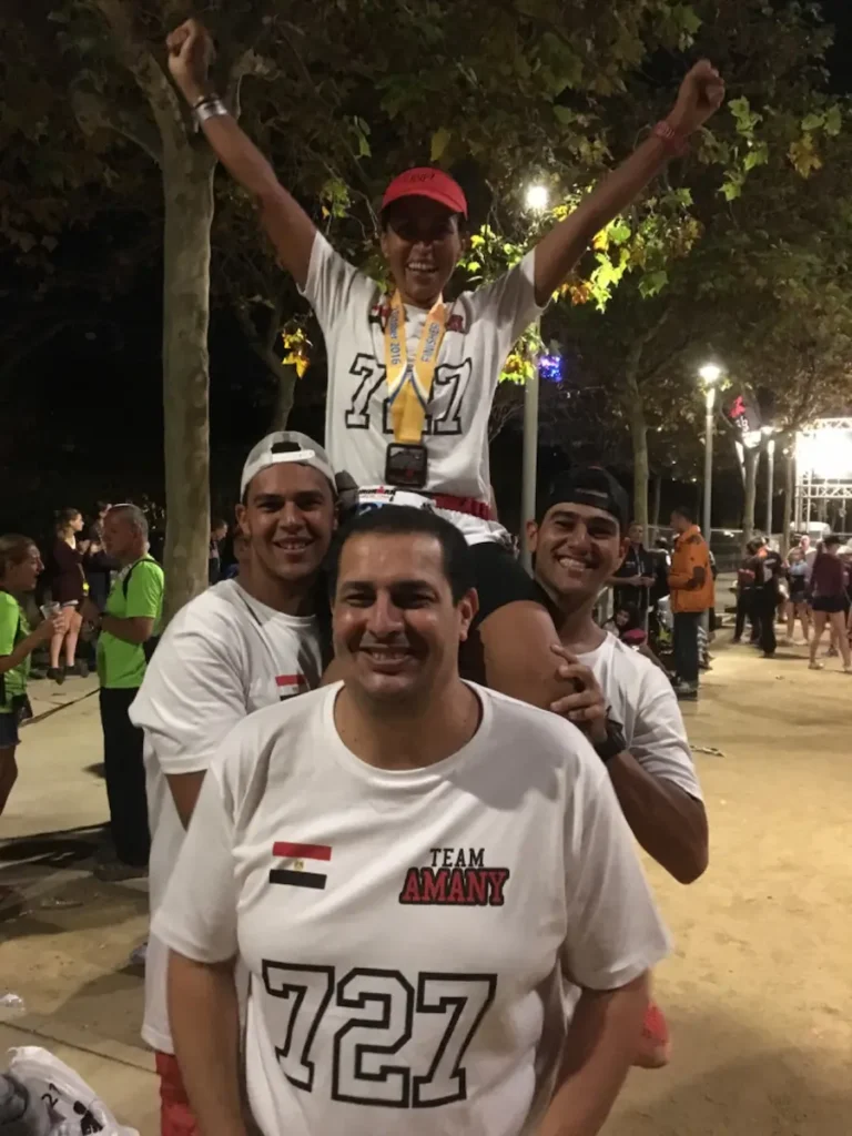 عائلة أماني خليل تحتفل بإنجازها، زوجها في المقدمة وأبنائها يحملونها خلفه احتفالاً بإكمال سباق الرجل الحديدي الكامل